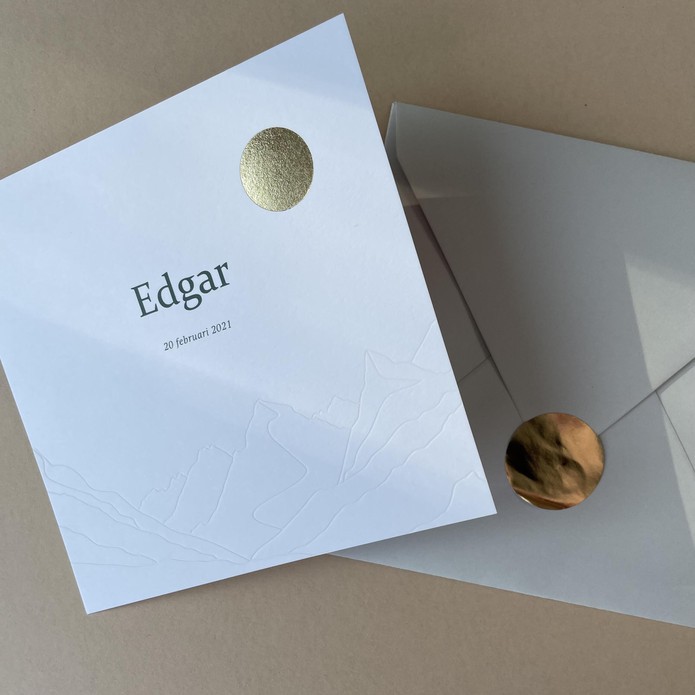 Geboortekaartje met goudfolie zon en bergen in reliëfdruk