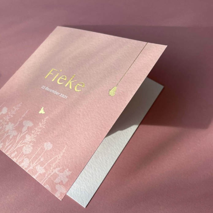 Romantisch geboortekaartje met bloemenveld en goudfolie