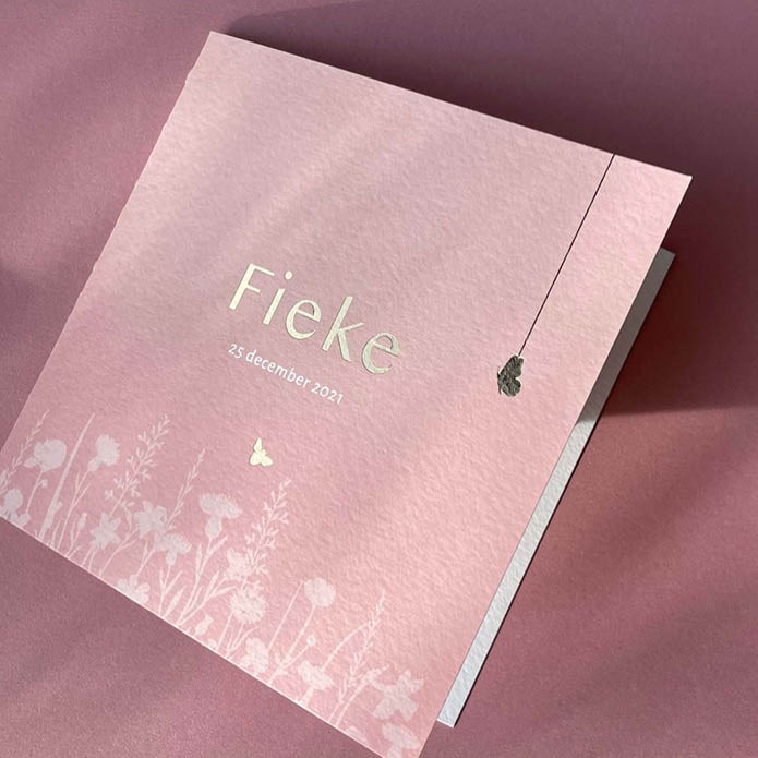 Romantisch geboortekaartje met bloemenveld en goudfolie