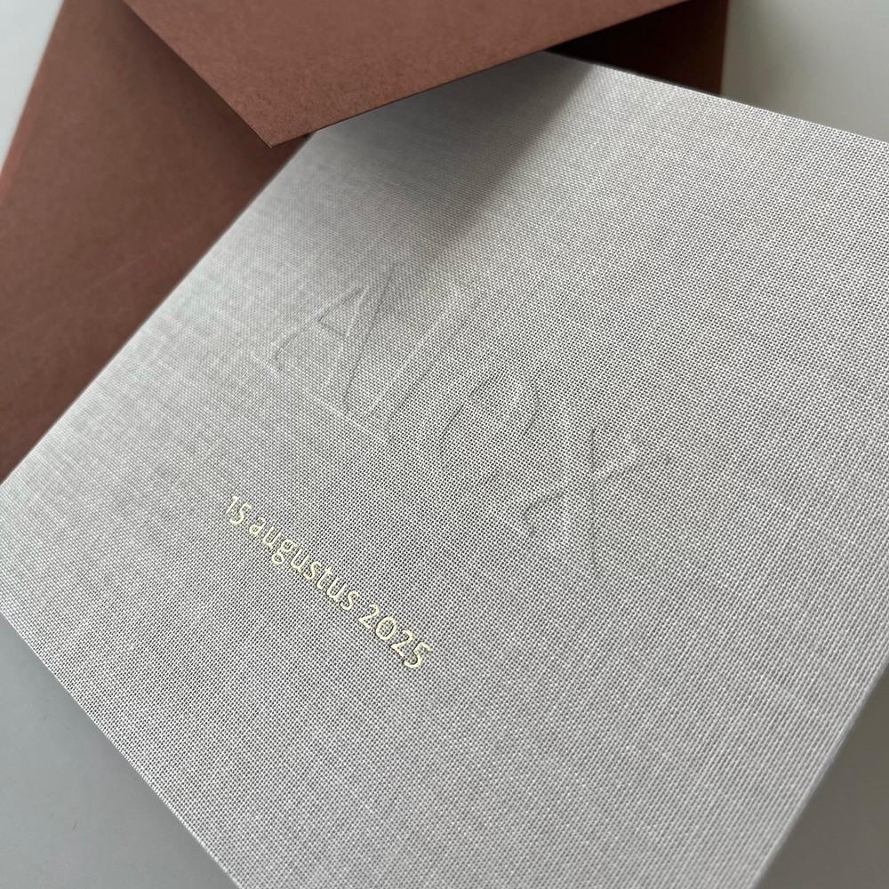 Gevouwen linnen geboortekaartje met subtiele reliëfdruk