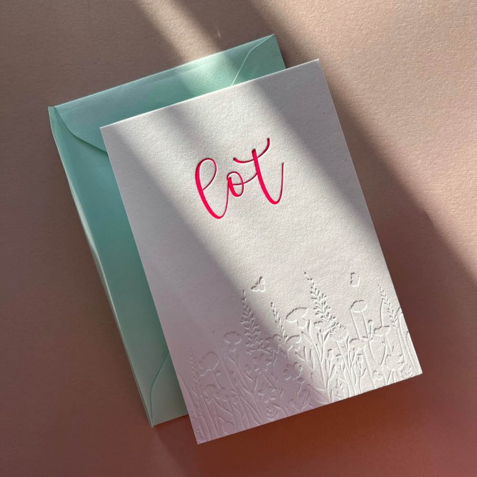 Romantisch geboortekaartje met bloemen veld in blinde druk en sierlijke naam van roze folie