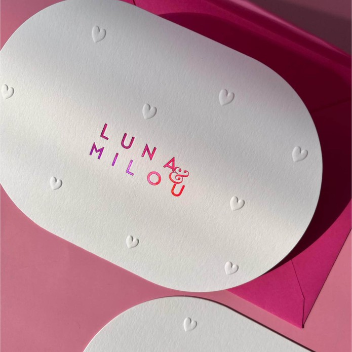 Ovaal geboortekaartje met roze foliedruk en reliëf hartjes voor tweeling meisje