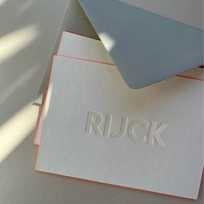 Minimalistisch geboortekaartje met witte folie en oranje zijkant