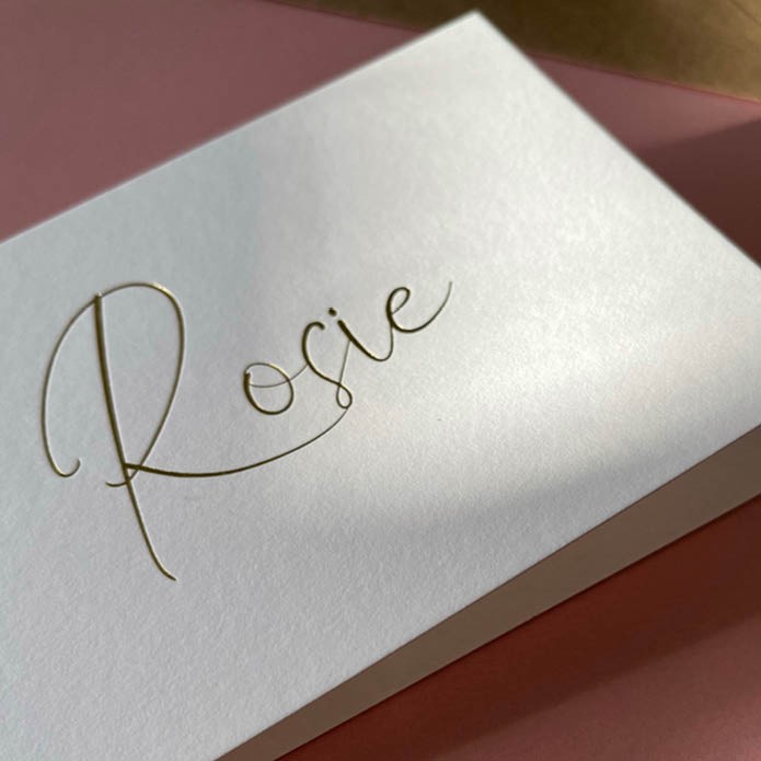 Stijlvol, dubbel gevouwen geboortekaart met sierlijke letters van goud