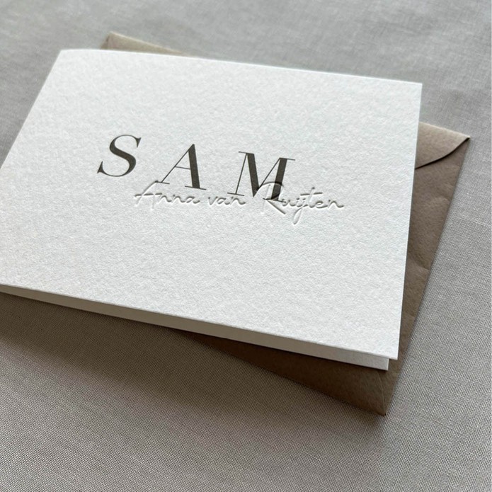 Minimalistisch geboortekaartje met voelbare achternaam in reliëfdruk