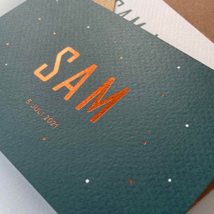 Petrol geboortekaartje met koper stipjes op de voorkant