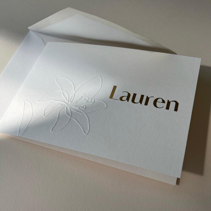 Tijdloos geboortekaartje met bloem reliëf en goudfolie naam – exclusief bij Festikaart